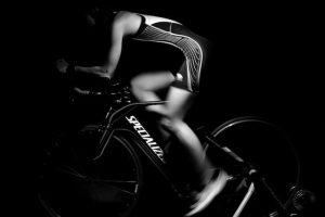 a black and white photo of a cyclist using an indoor bike