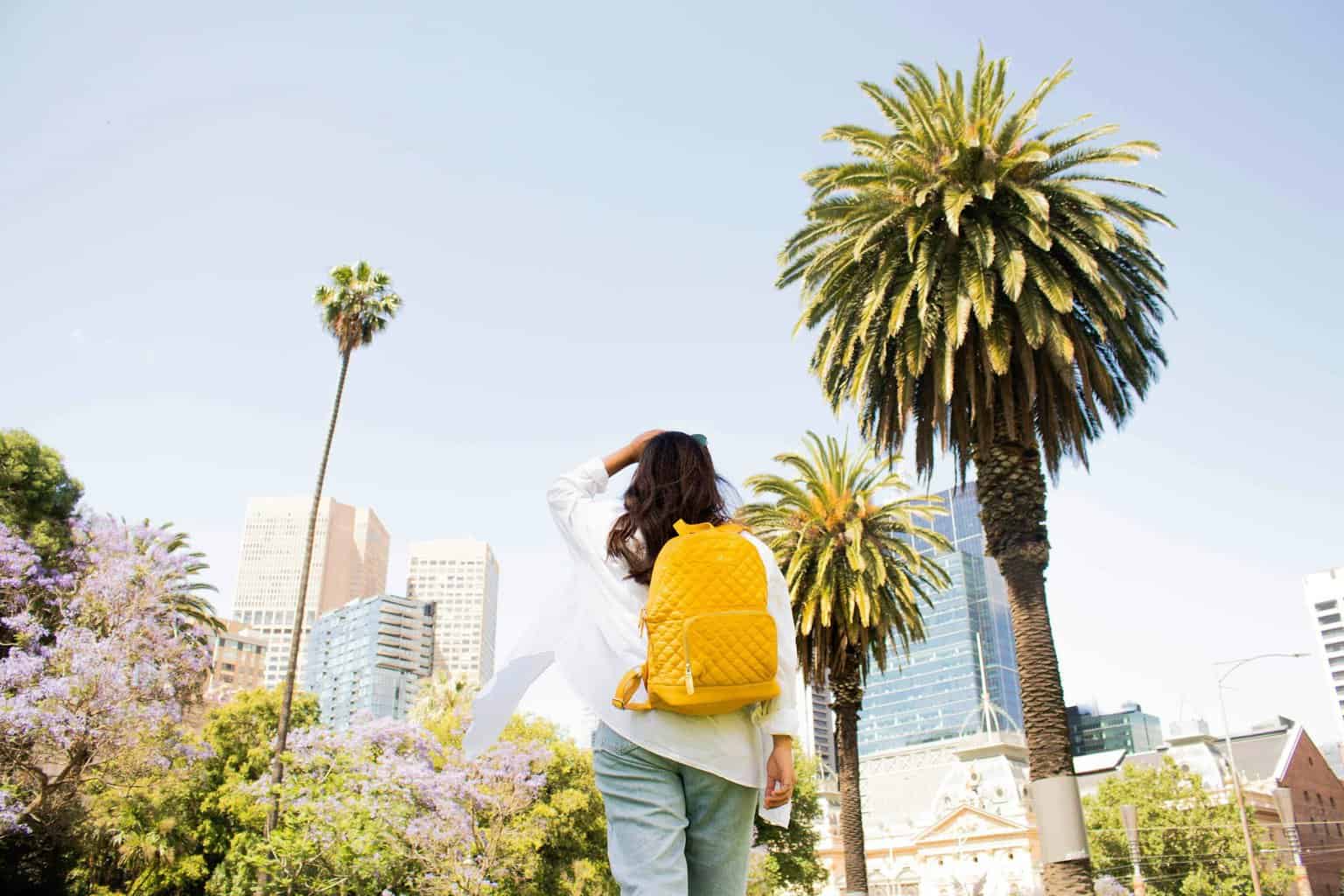 woman standing near palm tree - featured image